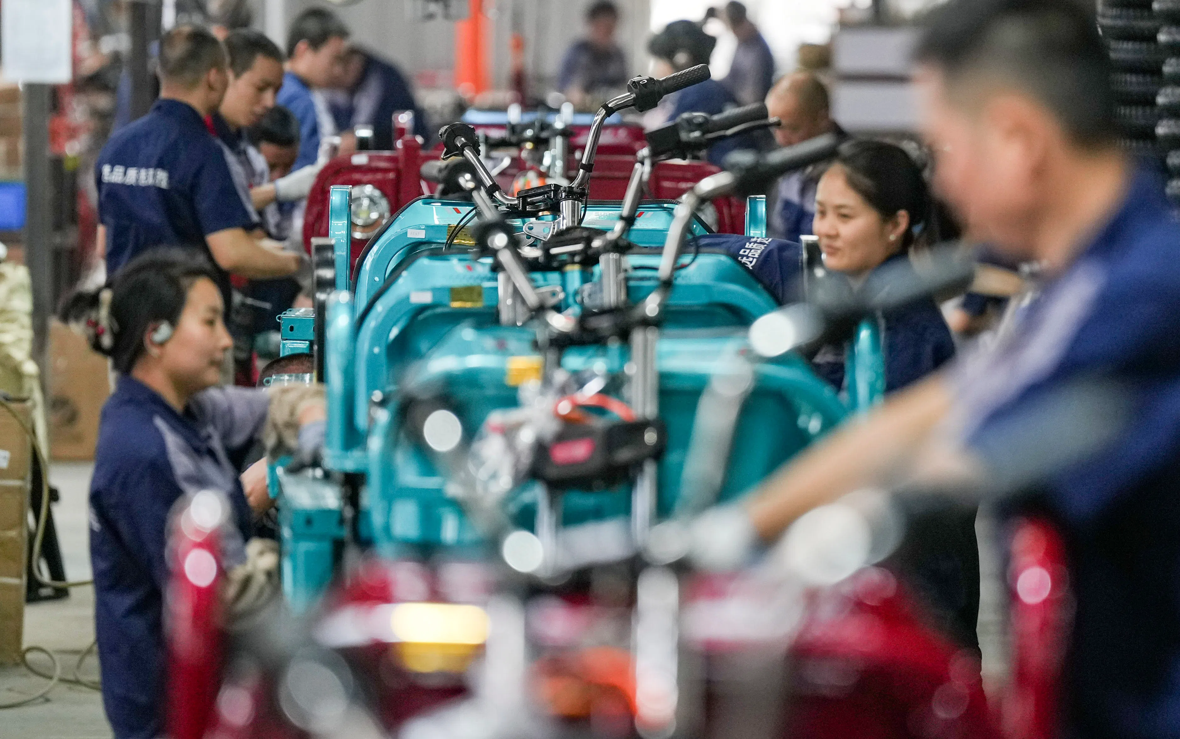 Workers assemble electric tricycles on the assembly line at the Shigao Industrial Park in the Tianfu New District of ​​Meishan, Sichuan, on 28 April 2025. (Wang Xi/Xinhua)