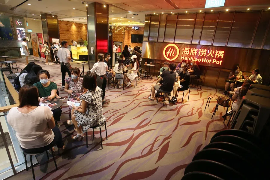 People wait to enter a Haidilao restaurant in Singapore. (SPH Media)