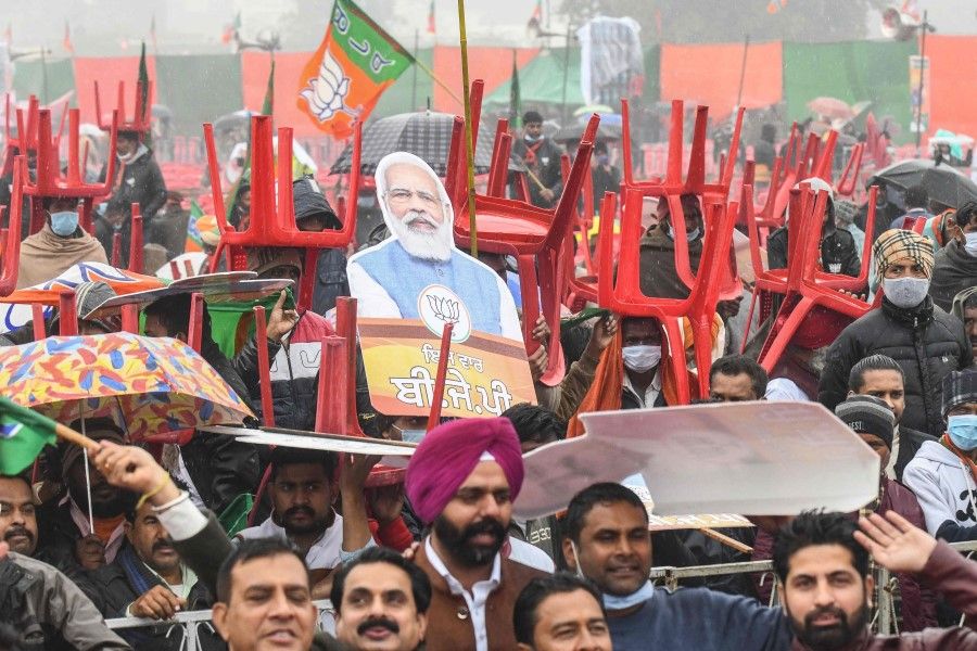 Bharatiya Janata Party (BJP) supporters hold chairs and cut-outs with portrait of BJP leader and India's Prime Minister Narendra Modi as they await his arrival during a rally ahead of the state assembly elections in Ferozepur on 5 January 2022 which was reportedly cancelled later citing security concerns. (Narinder Nanu/AFP)