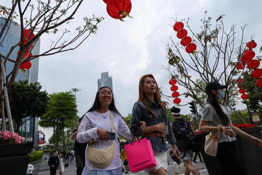 People walk at a business and shopping area in Guangzhou, Guangdong province, China, on 17 March 2026.