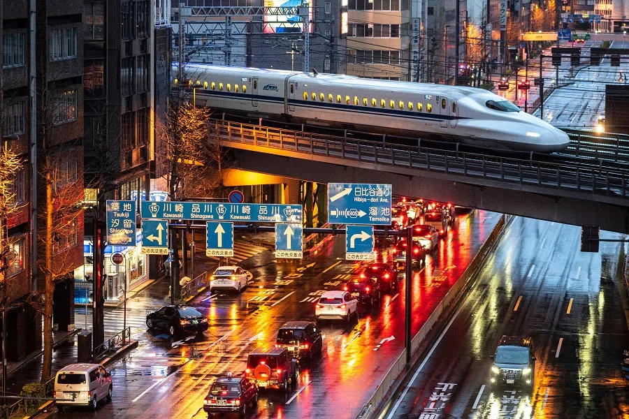 A Shinkansen N700 series, or high-speed bullet train, arrives at night in Tokyo, Japan, on 21 March 2021. (Charly Triballeau/AFP)