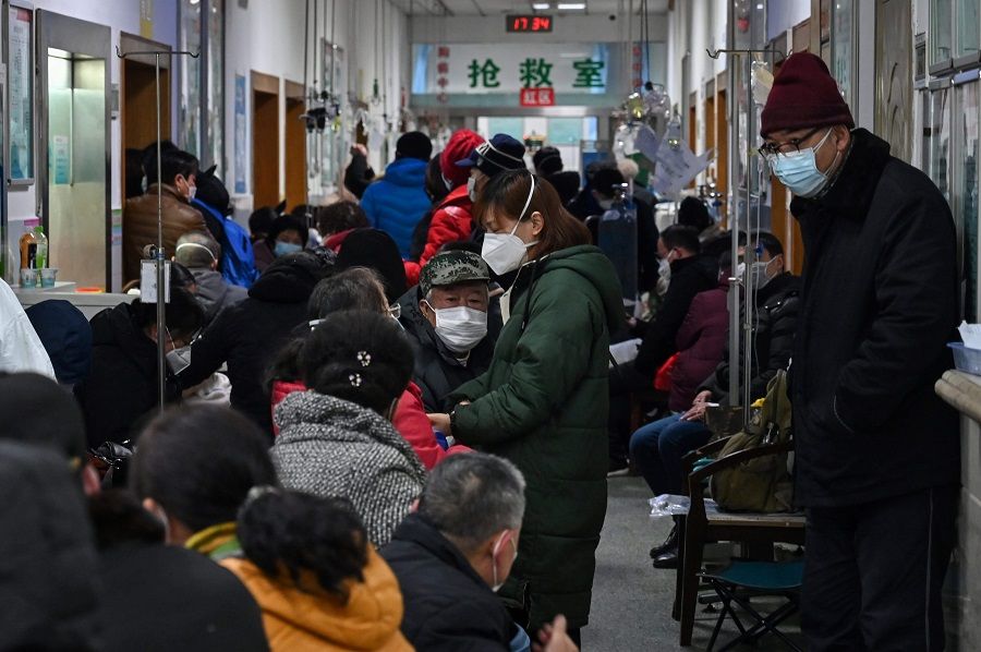 This file photo taken on 25 January 2020 shows people wearing face masks waiting for medical attention at Wuhan Red Cross Hospital in Wuhan. (Hector Retamal/AFP)