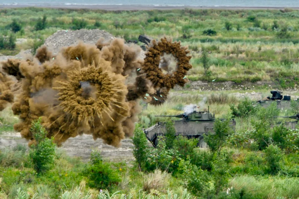 Two domestically-made armoured vehicles launch smoke grenades during the annual Han Kuang military drills in Taichung on 16 July 2020. - The military drills aimed to test how the armed forces would repel an invasion from China, which has vowed to bring Taiwan back into the fold - by force if necessary. (Sam Yeh/AFP)