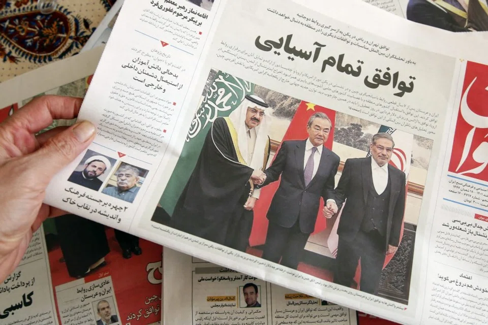 A man in Tehran holds a local newspaper reporting on its front page the China-brokered deal between Iran and Saudi Arabia to restore ties, signed in Beijing the previous day, on 11 March 2023. (Atta Kenare/AFP)