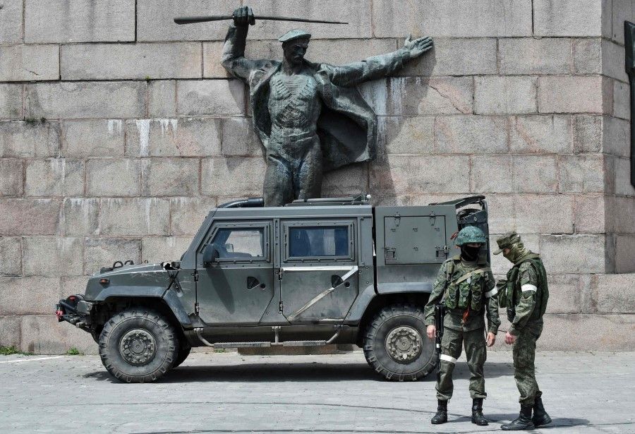 In this file photo taken on 20 May 2022, Russian servicemen patrol the Eternal Flame monument in Kherson, Ukraine, amid the ongoing Russian military action in Ukraine. (Olga Maltseva/AFP)