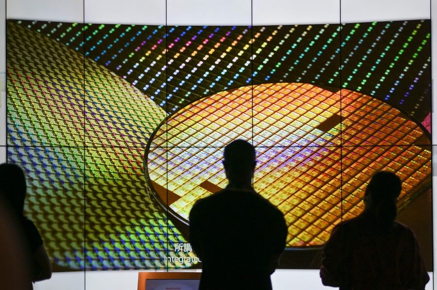 Visitors watch a wafer shown on screens at the Taiwan Semiconductor Manufacturing Company (TSMC) Renovation Museum at the Hsinchu Science Park in Taiwan on 5 July 2023. (Sam Yeh/AFP)