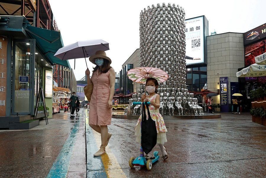 People wear protective face masks at a shopping complex in Beijing, China, on 17 July 2020. (Thomas Peter/Reuters)
