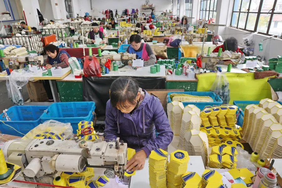 Workers produce footballs at a factory in Nantong in China's eastern Jiangsu province on 29 November 2022. (AFP)