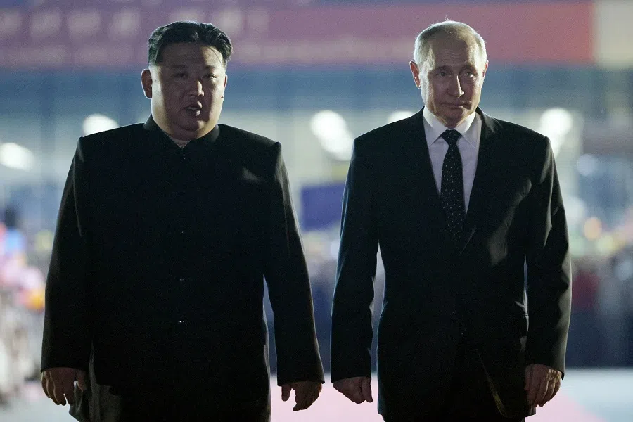 In this file pool photograph taken on 19 June 2024 and distributed by the Russian state agency Sputnik, Russian President Vladimir Putin (right) and North Korean leader Kim Jong Un walk during a farewell ceremony upon Putin’s departure at the Sunan International Airport in Pyongyang.