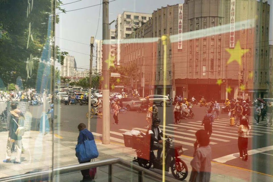 Chinese flags and pedestrians reflected in a window in Shanghai, China, on 2 June 2023. (Raul Ariano/Bloomberg)