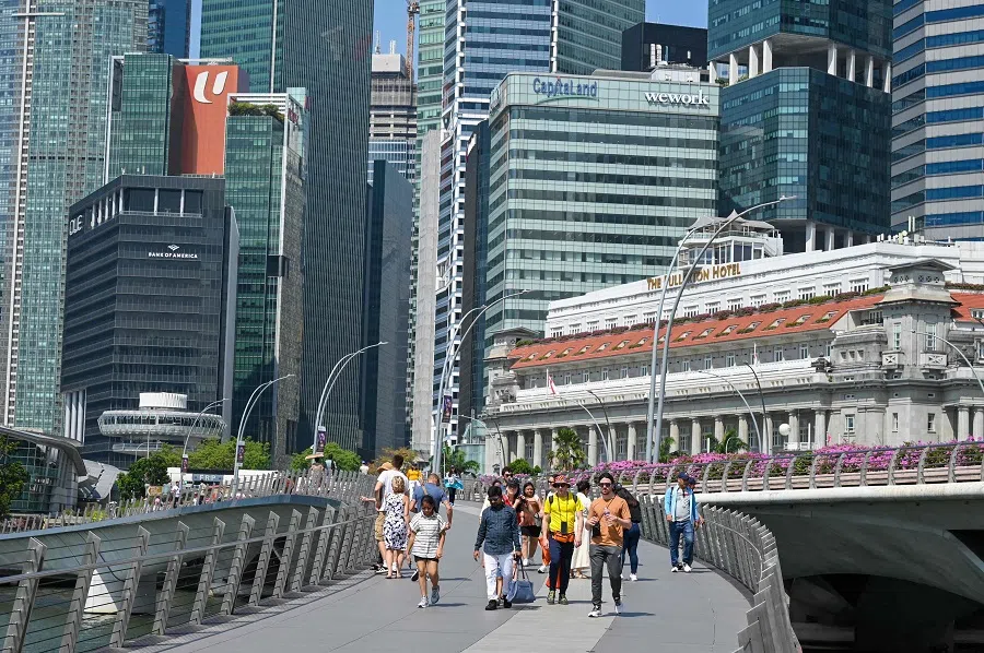 People walk across Jubilee Bridge on Marina Bay in Singapore on 25 May 2023. (Roslan Rahman/AFP)