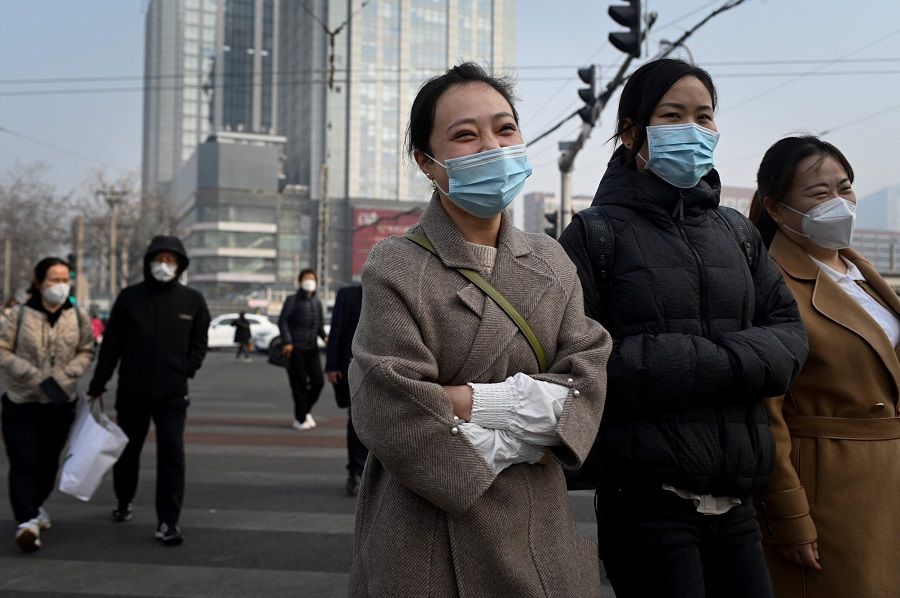 Pedestrians cross a street in Beijing, China, on 5 March 2023. (Wang Zhao/AFP)