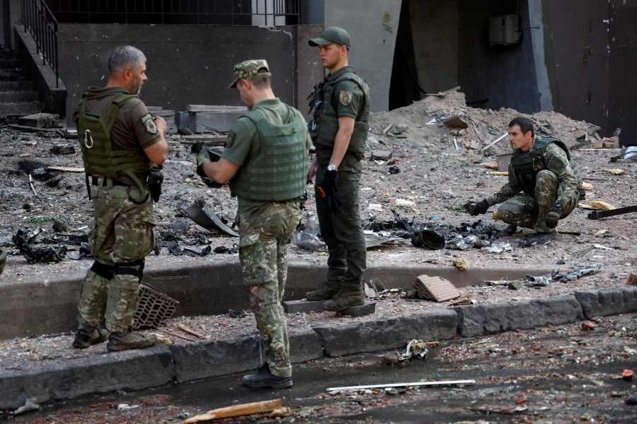 Officers inspect the remains of missile outside a residential building hit by a Russian missile strike, as Russia's attack on Ukraine continues, in Kyiv, Ukraine, 26 June 2022. (Valentyn Ogirenko/Reuters)
