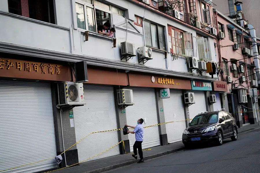 A resident pulls a rope to pick up a bag at a closed residential area during lockdown, amid the Covid-19 pandemic, in Shanghai, China, 8 May 2022. (Aly Song/Reuters)