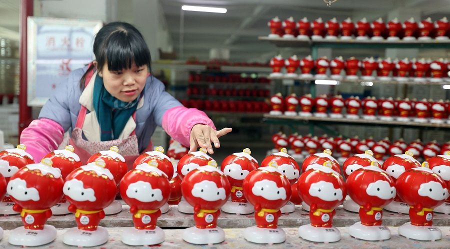 This photo taken on 14 January 2022 shows a worker arranging porcelain figures of 2022 Beijing Winter Paralympic Games mascot Shuey Rhon Rhon at a factory in Quanzhou, Fujian province, China. (AFP)