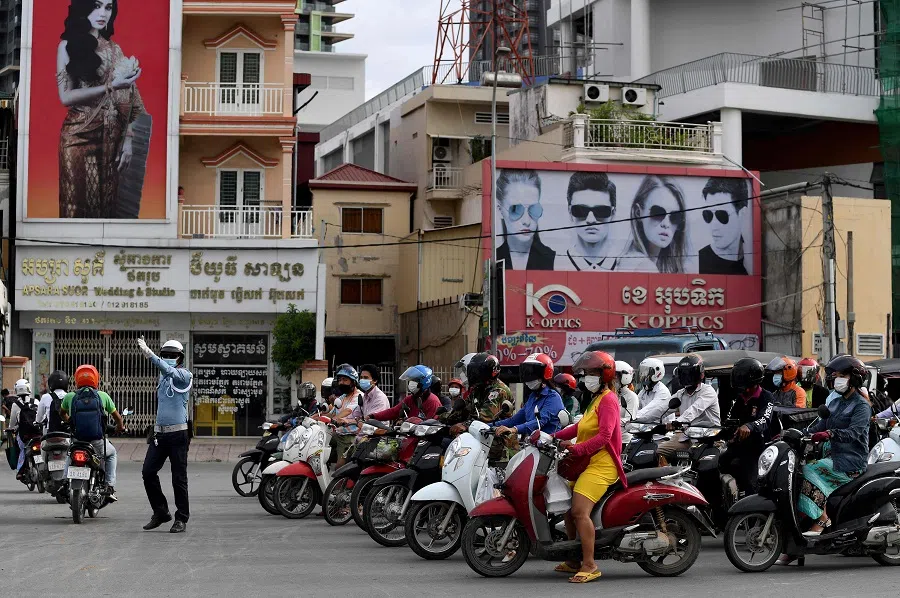 A traffic police directs traffic along a street in Phnom Penh, Cambodia, on 26 August 2021. (Tang Chhin Sothy/AFP)