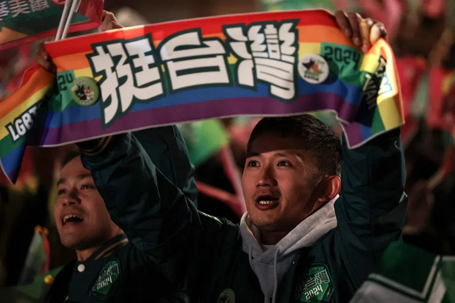 A supporter of Taiwan's Vice President and presidential candidate of the ruling Democratic Progressive Party (DPP) Lai Ching-te holds up a banner while waiting for the results of the presidential elections outside the party's headquarters in Taipei, Taiwan, on 13 January 2024. (Yasuyoshi Chiba/AFP)