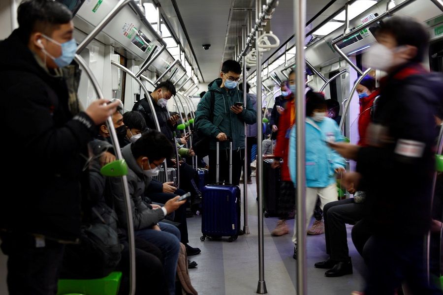 Passengers use their phones on a subway in Beijing, China, 2 February 2023. (Tingshu Wang/Reuters)