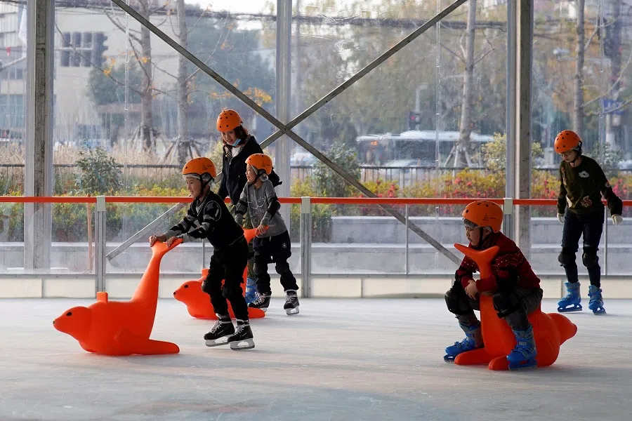 People skate at an ice rink outside a shopping mall in Shanghai, China, 10 December 2021. (Aly Song/Reuters)