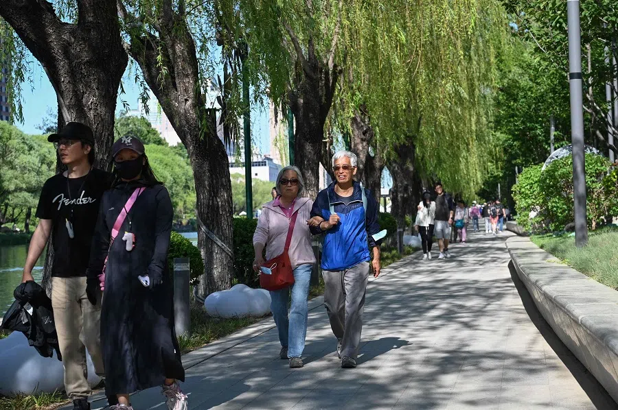 People walk along a canal in Beijing, China, on 12 May 2024. (Jade Gao/AFP)