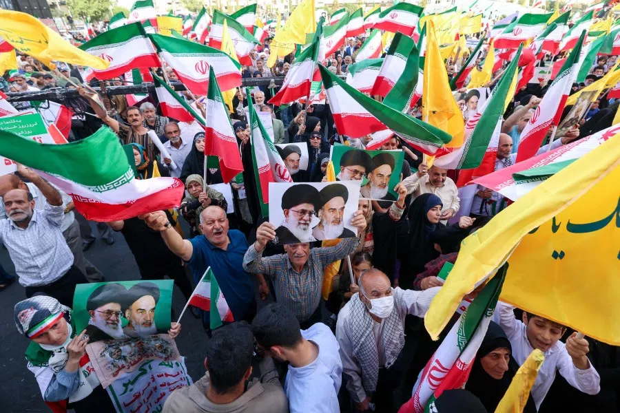 Iranians hold portraits of Iranian supreme leader Ayatollah Ali Khamenei (left) and late supreme leader Ayatollah Ruhollah Khomeini at Enghlab Square in the capital Tehran on 24 June 2025. (Atta Kenare/AFP)