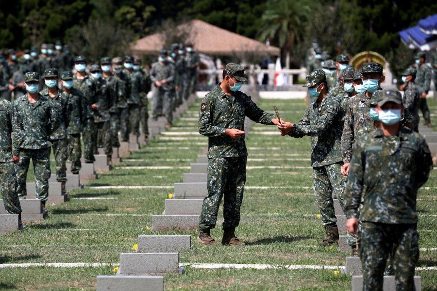 Soldiers pass incense to each other to pay respects to the deceased, during an event to mark the 62nd anniversary of the Second Taiwan Strait crisis in Kinmen, Taiwan, 23 August 2020. (Ann Wang/REUTERS)