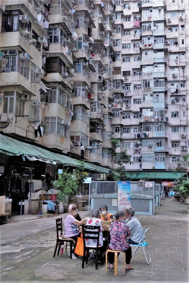 People play card games in an open area of a residential building in Hong Kong on 21 August 2021. (Bertha Wang/AFP)