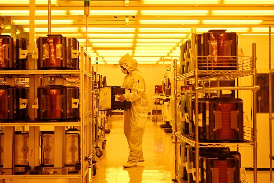 A worker in the clean room processing Wafer-level packaging (WLP) at the Singapore semiconductor firm, STATS ChipPAC office in Yishun on 12 April 2023. (SPH Media)