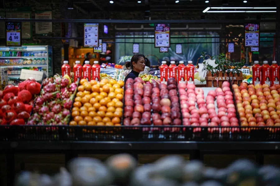 A woman shops for vegetables and fruits at a market in Yuncheng, Shanxi province, China, on 13 October 2024. (AFP)