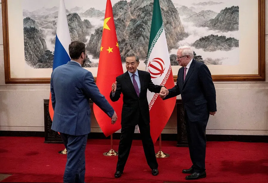 Chinese Foreign Minister Wang Yi welcomes Russian Deputy Foreign Minister Sergey Ryabkov and Iranian Deputy Foreign Minister Kazem Gharibabadi, before a meeting regarding the Iranian nuclear issue at Diaoyutai State Guest House on 14 March 2025, in Beijing, China. (Reuters)