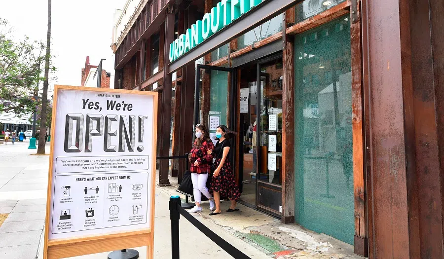 In this file photo taken on 26 June 2020, women step out of a re-opened Urban Outfitters store at Santa Monica's Third Street Promenade shopping district in Santa Monica, California. (Frederic J. Brown/AFP)