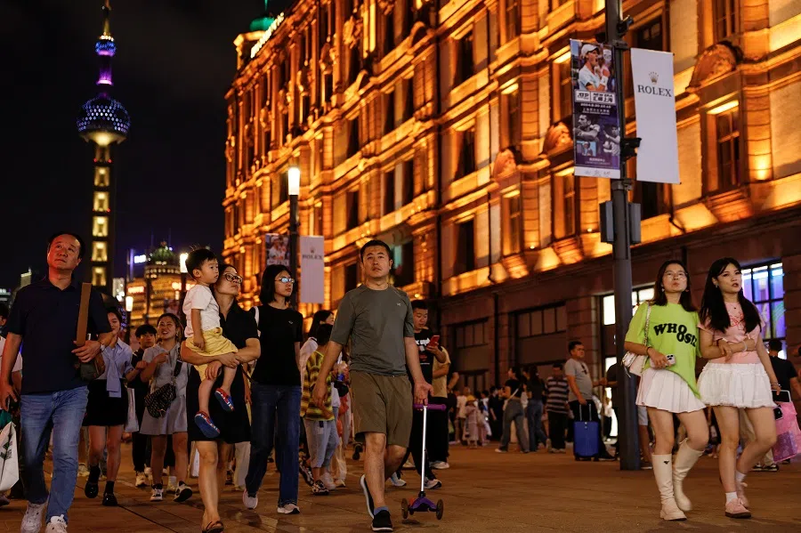 People walk at a pedestrian street near the Bund in Shanghai, China, on 28 September 2024. (Tingshu Wang/Reuters)