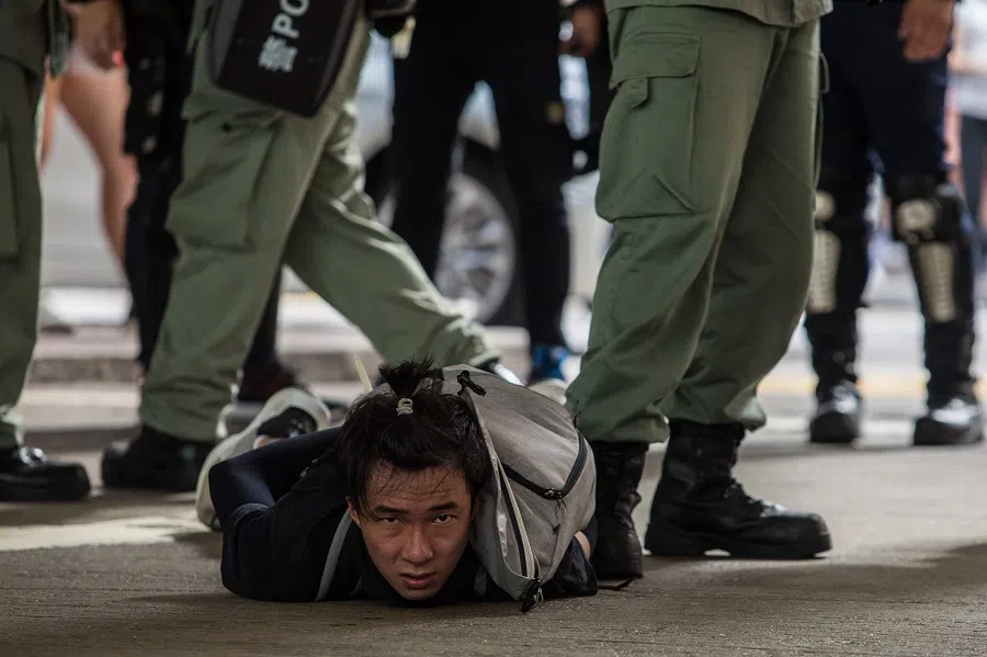 Riot police detain a man as they clear protesters taking part in a rally against a new national security law in Hong Kong on 1 July 2020. (Dale De La Rey/AFP)