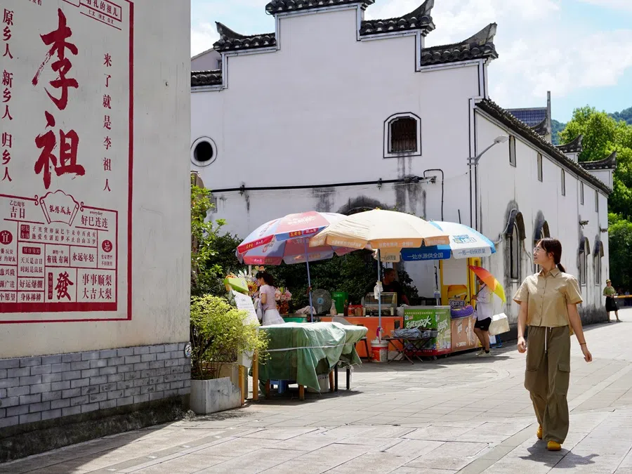 A tourist admiring a mural in Yiwu on 7 August 2025.  (CNS)