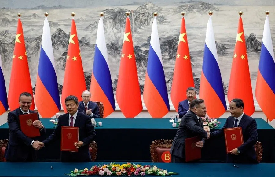 Russian President Vladimir Putin and Chinese President Xi Jinping look on as officials exchange with agreement folders during a signing ceremony at the Great Hall of the People in Beijing, China, 20 May 2026.