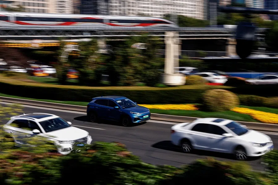 An electric vehicle moves on a street in Beijing, China, on 20 October 2023. (Tingshu Wang/Reuters)
