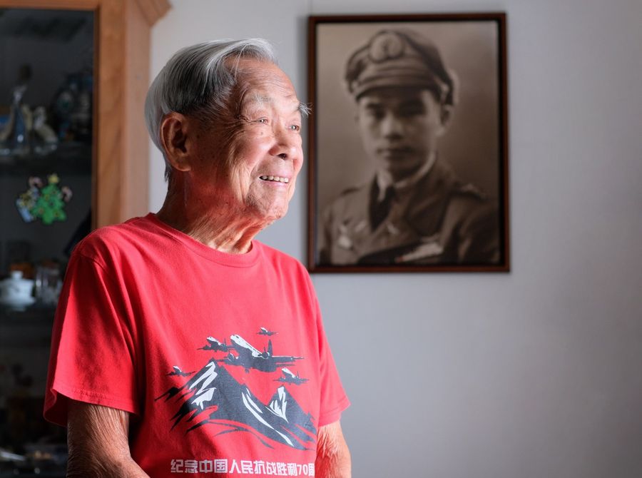 Centenarian Ho Weng Toh is not only a WWII veteran, SIA pioneer pilot, but also a published author of his autobiography. A picture of him taken in 1945, hangs on the wall. (Long Kwok Hong/SPH)