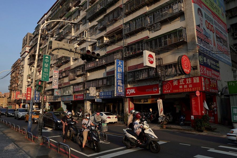 People ride their motorbikes during sunset hours in New Taipei City, Taiwan, 14 July 2022. (Ann Wang/Reuters)