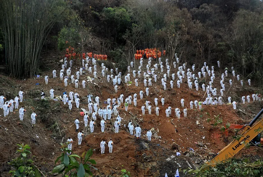 Rescue workers stand in a silent tribute at the site to mourn the victims of a China Eastern Airlines Boeing 737-800 plane, flight MU5735, that crashed in Wuzhou, Guangxi Zhuang Autonomous Region, China, 27 March 2022. (CNS photo via Reuters)