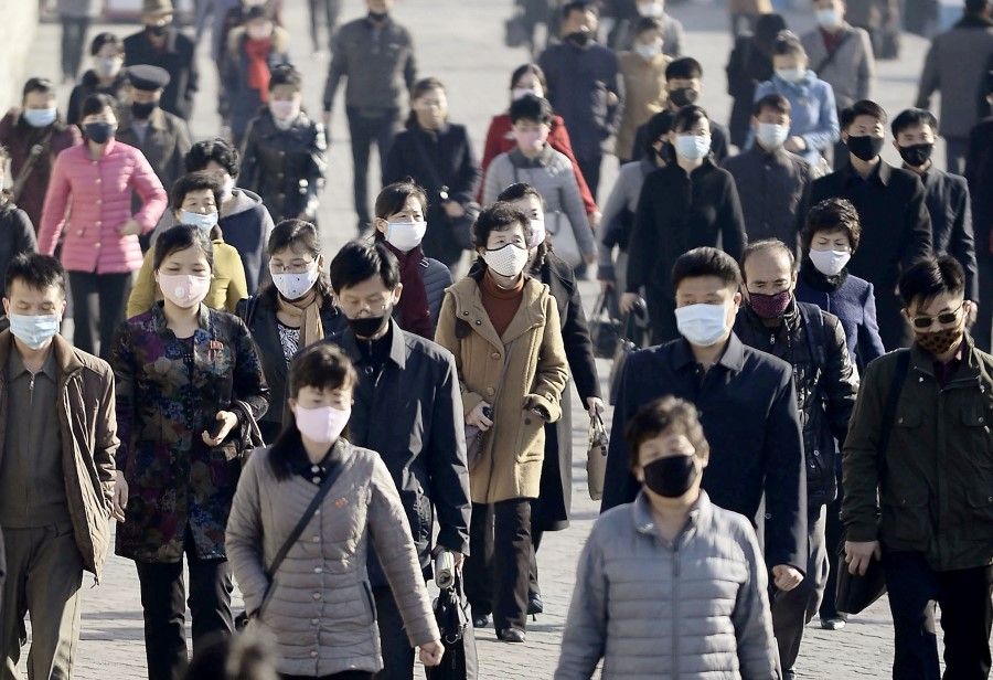 People wearing protective face masks commute amid concerns over the new coronavirus disease (COVID-19) in Pyongyang, North Korea, 30 March 2020, in this photo released by Kyodo. (Kyodo/via REUTERS)