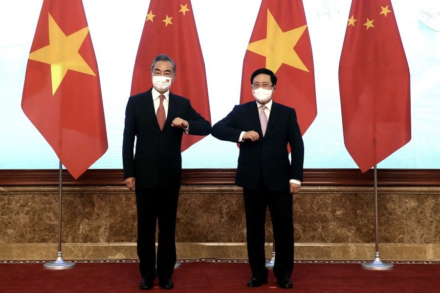 This picture taken and released by the Vietnam News Agency on 10 September 2021 shows Vietnam's Deputy Prime Minister Pham Binh Minh (right) bumping elbows to greet China's Foreign Minister Wang Yi (left) prior to a meeting in Hanoi. (STR/Vietnam News Agency/AFP)