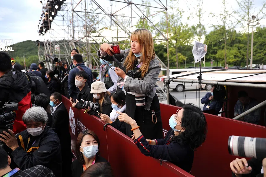A media member uses her phone during a red carpet ceremony at the Beijing International Film Festival, in Beijing, China, 20 September 2021. (Tingshu Wang/Reuters)