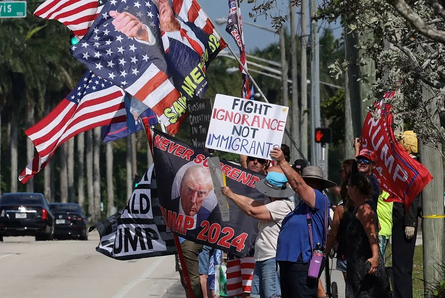 Anti-Trump and pro-Trump demonstrators hold flags and placards at the entrance to Trump International Golf Club where US President Donald Trump spent his day in West Palm Beach, Florida, US, on 2 March 2025. (Kevin Lamarque/Reuters)