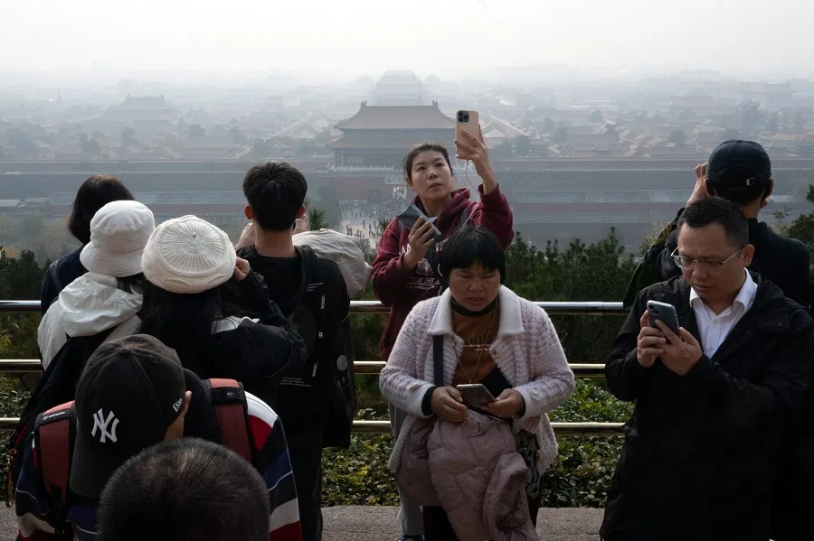 Tourists take photographs with the Forbidden City in Beijing, China, on 8 November 2024. (Bloomberg)