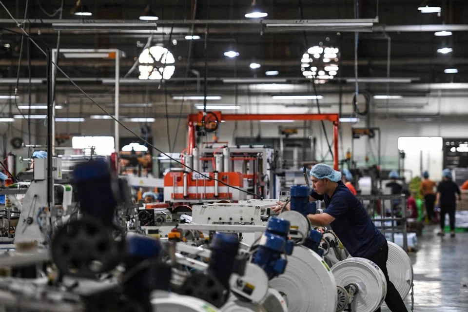 This picture taken on 2 December 2022 shows an employee working inside a packaging factory of Nam Thai Son Group in Ho Chi Minh City. (Nhac Nguyen/AFP)