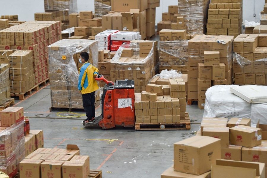 An employee transfers items for delivery ahead of the Singles' Day shopping festival which falls on 11 November , at a logistics center in Nanjing, in China's eastern Jiangsu province on 10 November 2022. (Photo by AFP)
