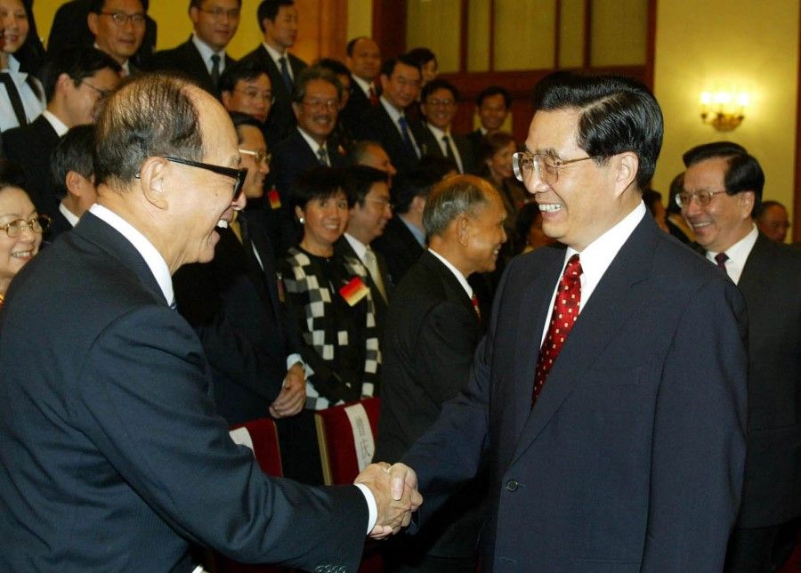 Li Ka Shing (left) shakes hands with Chinese President Hu Jintao at an event in Beijing on 27 September 2003. (CNS)