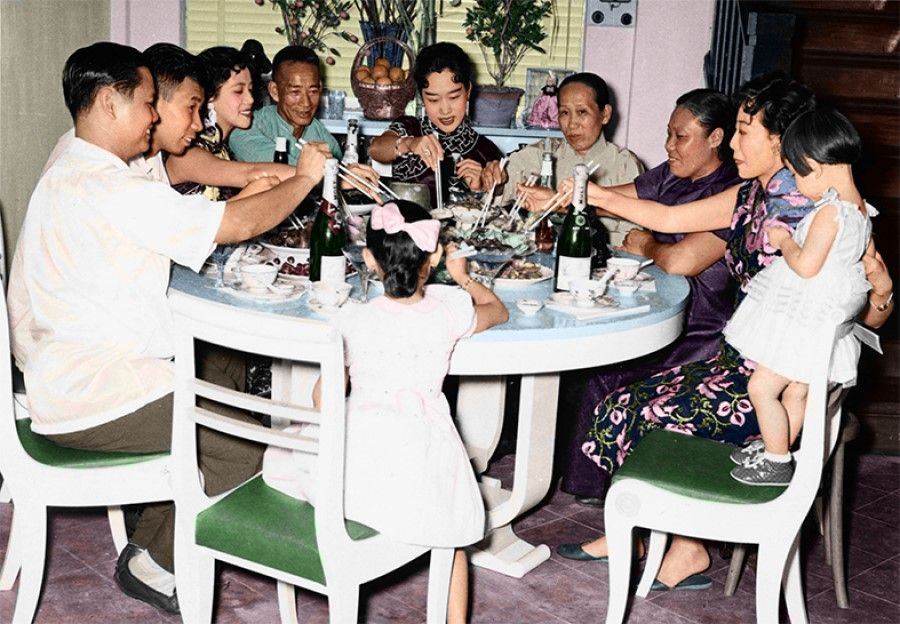 A reunion meal on the eve of the Chinese New Year in the late 1970s with family members wearing new clothes to celebrate the occasion. The festive mood reflects the growing affluence in Singapore society.