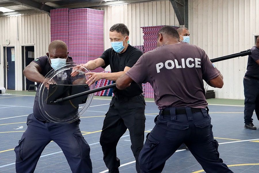 An undated handout photo released on 29 March 2022 by the Royal Solomon Islands Police Force (RSIPF) shows a China Police Liason Team officer (centre) training local RSIPF officers. (Handout/Royal Solomon Islands Police Force/AFP)