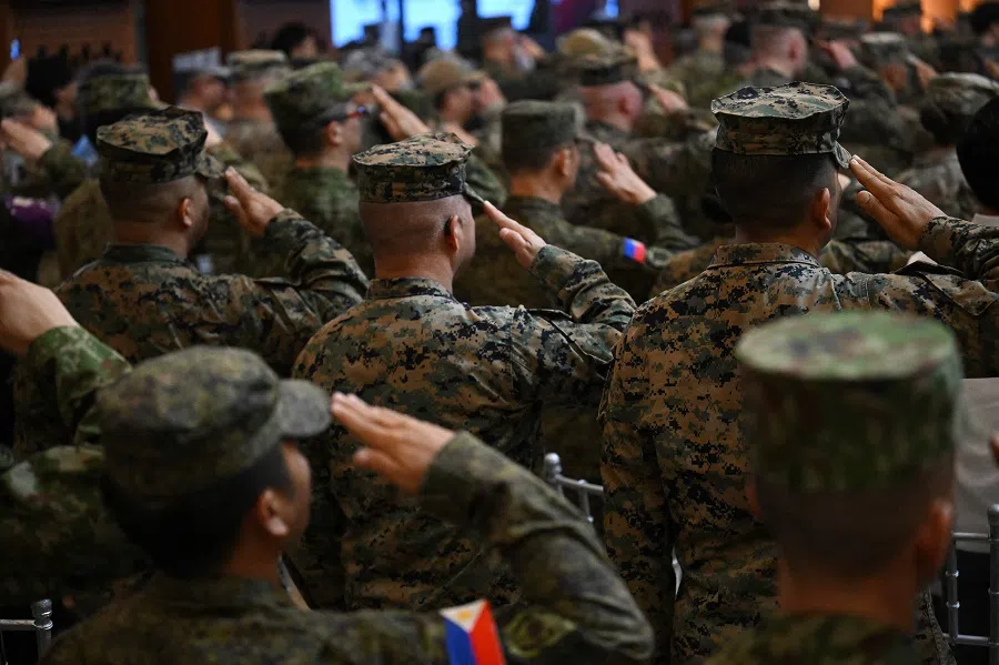 US and Philippine soldiers salute as their national anthems are played during the opening ceremony of the annual US-Philippines Balikatan joint military exercise at camp Aguinaldo in Manila, Philippines, on 21 April 2025. (Ted Aljibe/AFP)